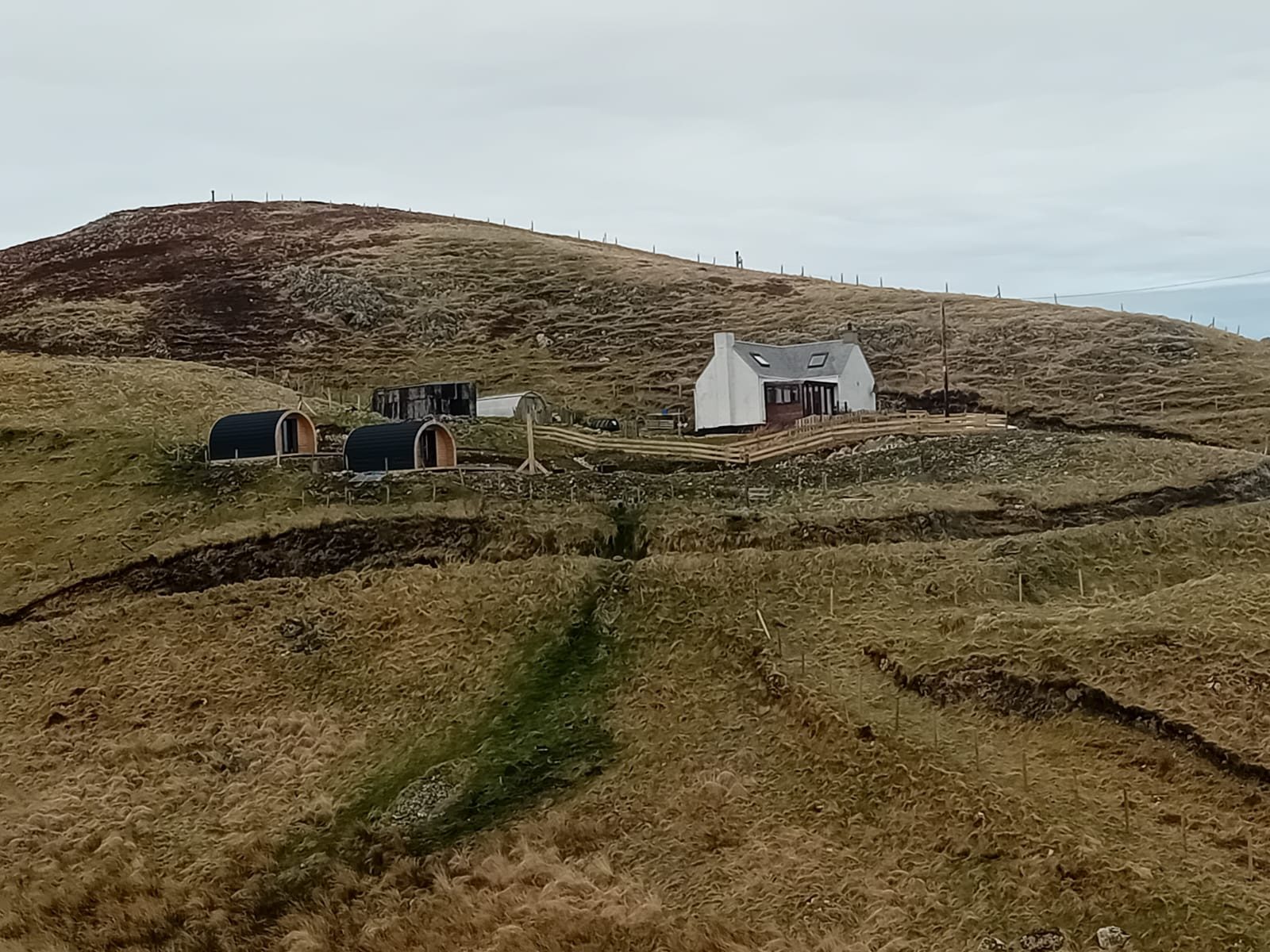 Croft house and glamping pods on the hillside